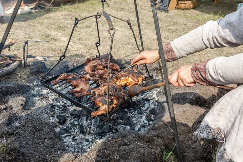 Ohniště v zemi s grilováním masa na otevřeném ohni