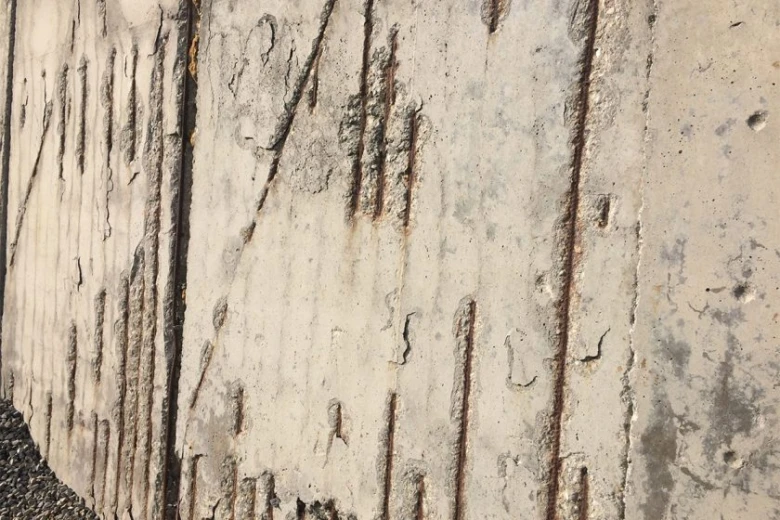 Poškozený venkovní beton s prasklinami a degradací povrchu