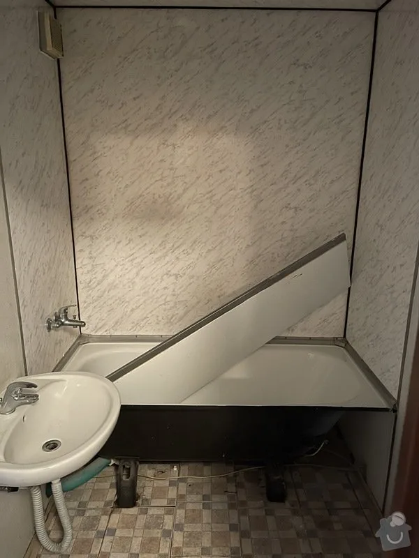 Stará koupelna s vany a umyvadlem připravená na renovaci.