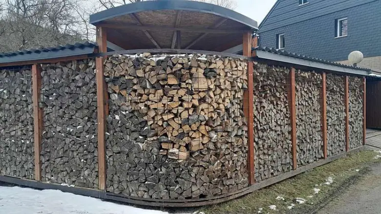 Hotový dřevník z kari sítě plný drahého paliva.