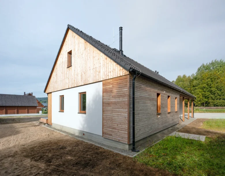 Modern dřevostavba s kombinací dřeva a bílých omítek.