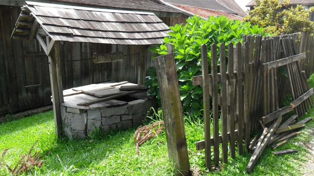 Starobylá studna s dřevěnou střechou na zahradě
