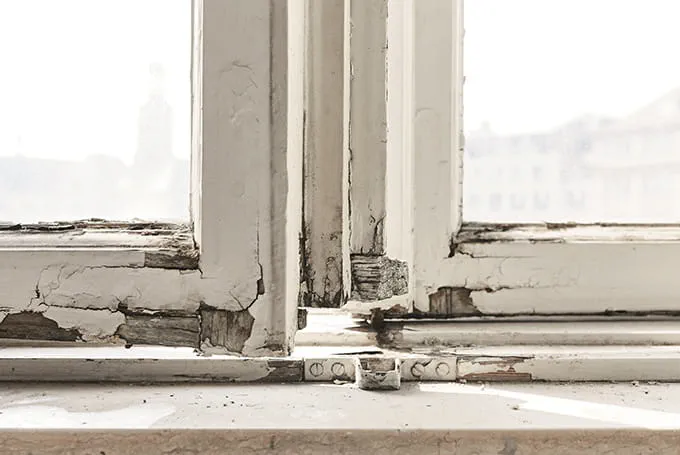 Poškozené dřevěné okno potřebující renovaci