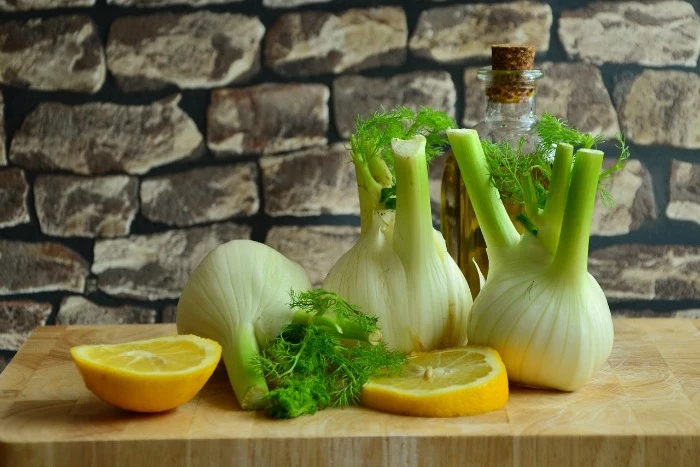 Čerstvý fenykl s citrony na dřevěném prknu.