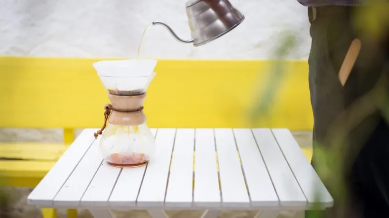 Připravování kávy metodou pour-over na venku.