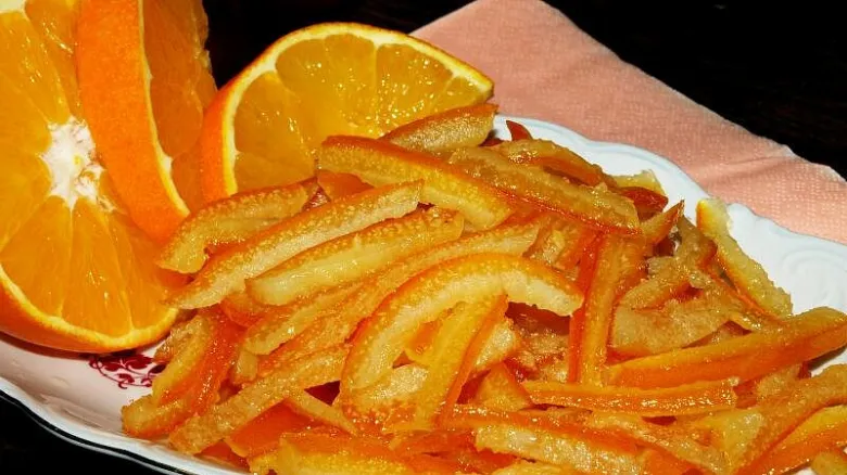 Kandované pomerančové kůrky s čerstvými plody na talíři.