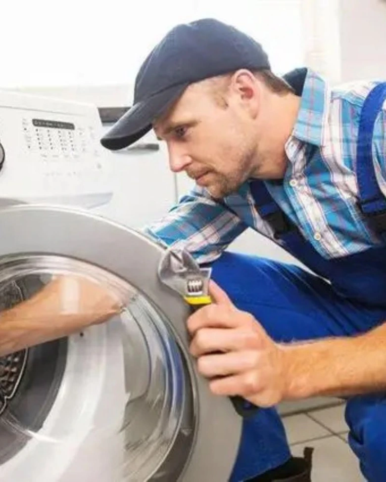 Technik opravuje pračku v Brně s klíčem