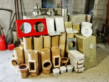 Sestava materiálů pro opravu komínu: cihly, trubky, izolace