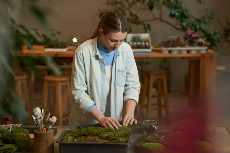 Žena pracuje s mechovými trávníky v zahradním dílně