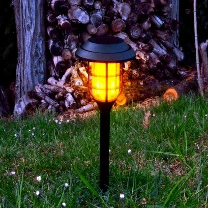 Sluneční lampa před domem s dřevěným štítem na podzim.