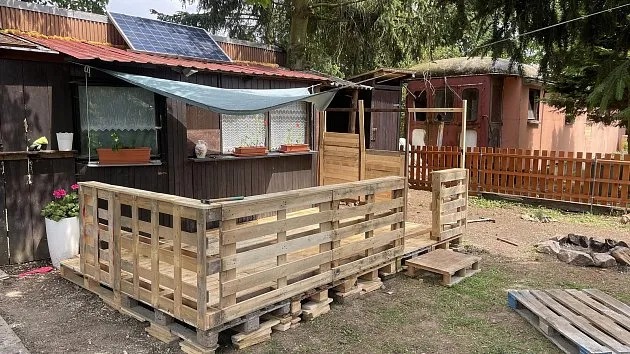 Terasa postavená z dřevěných palet v zahradě.