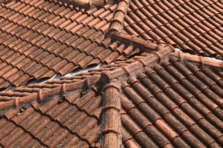 Stará lepenková střecha s poškozenými taškami.
