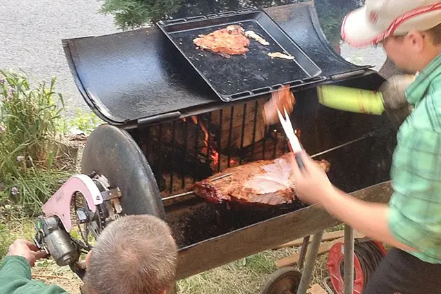 Muž griluje na domácím roštu venku.