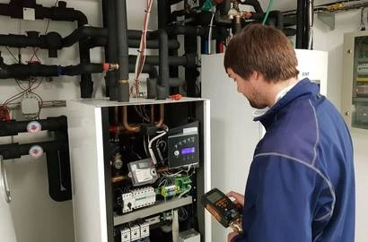 Technik provádí revizi tepelného čerpadla s měřicím přístrojem