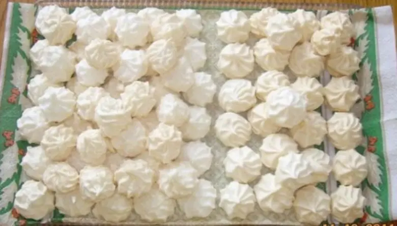 Tray of freshly baked homemade meringues made from egg whites.