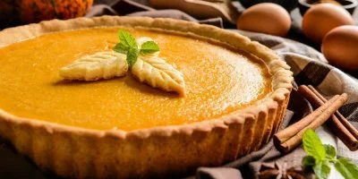 Pumpkinový koláč s listovými dekoracemi na vrchu.