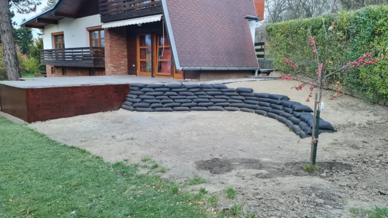 Dřevěné zpevnění svahu s pytlovými vaky pro zahradu.