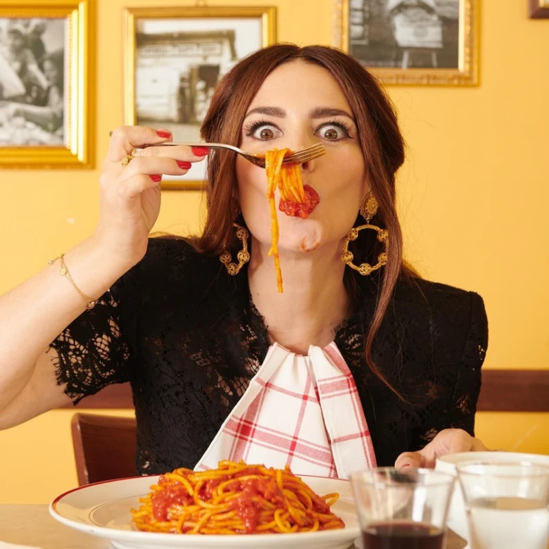 Žena jí italské špagety s rajčatovou omáčkou v restauraci.