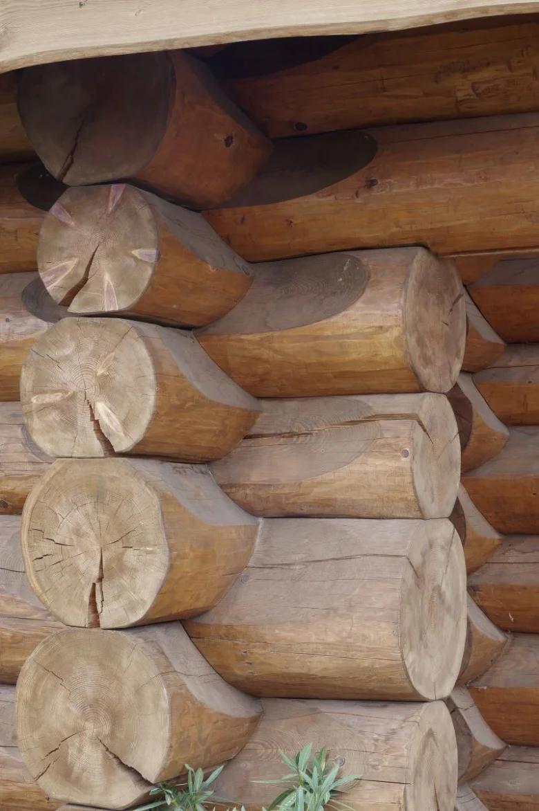 Detail roubené stavby z přírodních dřevěných trámů.