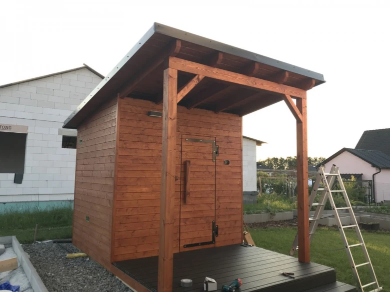 Dřevěná venkovní sauna s přístřeškem na zahradě