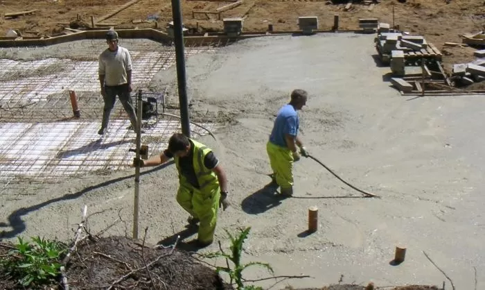 Práce na betonové základní desce stavebního pozemku.