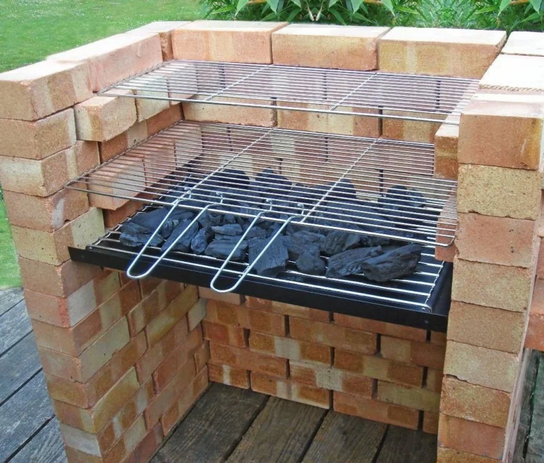 Dokončený gril z cihel s mřížkami a uhlím