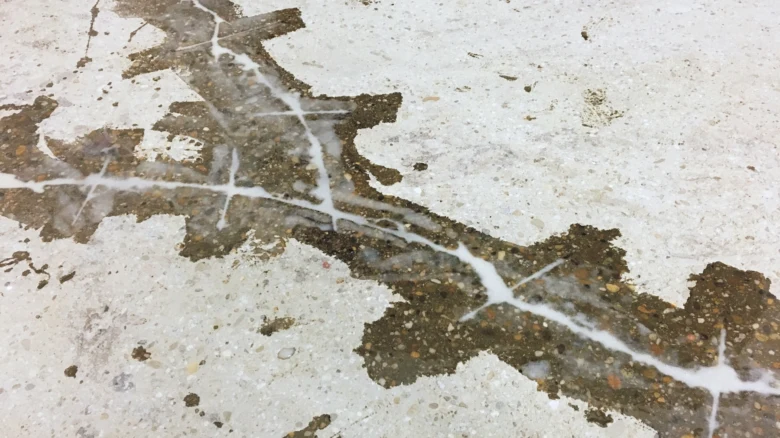 Poškozená podlaha s prasklinami vyžadující vyrovnání.