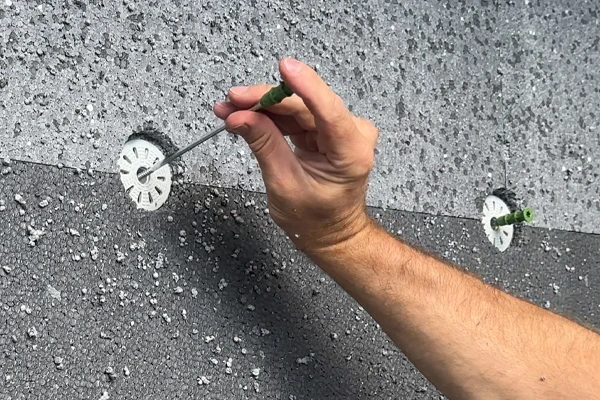 Ruční instalace hmoždinky do polystyrenu pomocí šroubováku.