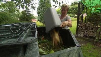 Žena přisypává zbytky jídla do kořenové čističky venku.