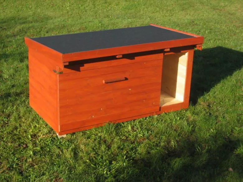 Dřevěný pesní domek na trávníku pro chov psů.