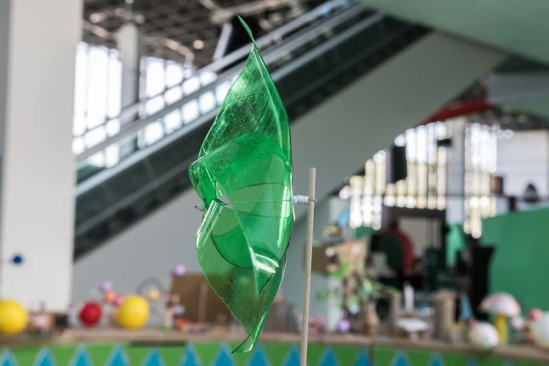 Zelený větrník z recyklované PET lahve na stůl.