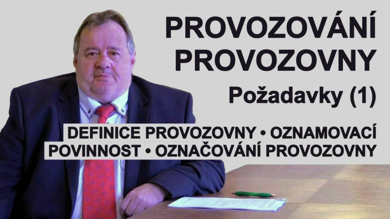 Muž v obleku před tabulí s textem o provozování provozovny.