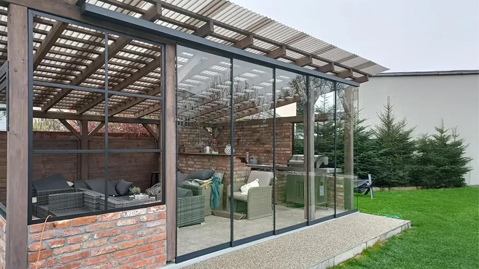Zasklená pergola s dřevěnou konstrukcí a skleněnými stěnami
