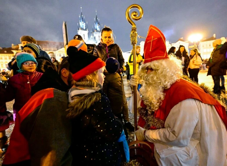 Svatý Mikuláš s dětmi na náměstí večer