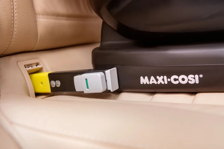 Isofix konektor v základně dětské autosedačky připojený k autu.