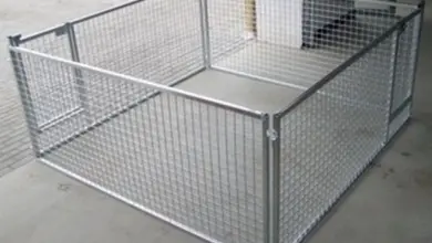 Ohrádka pro štěně z drátěné sítě na betonové podlaze.