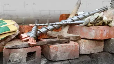 Vrtací vřetena ležící na cihlách s náradím pro práci se zdivem.