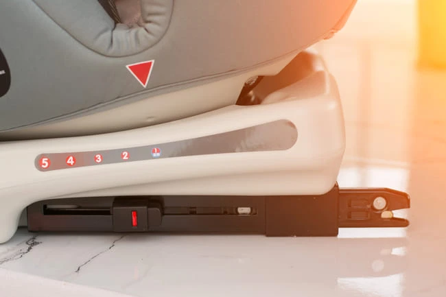 Bílá plastová základna dětské autosedačky s nastavitelným isofix systémem.