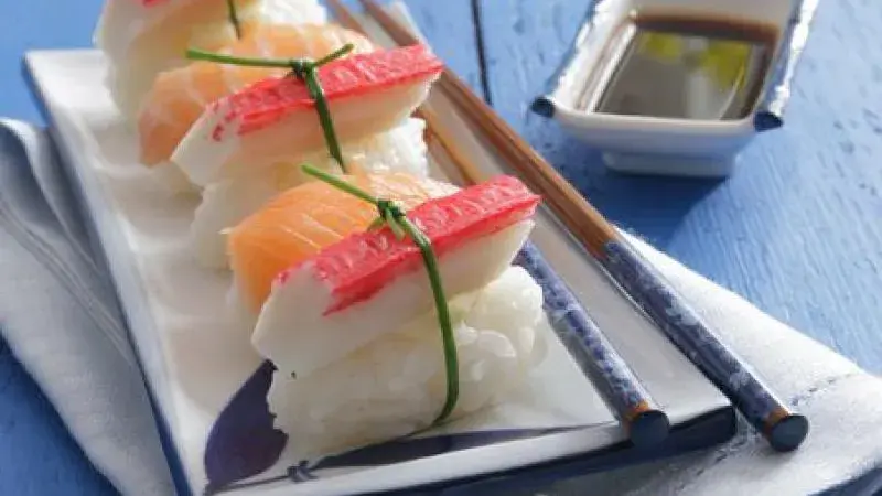 Japonské sushi s krabími tyčinkami na bílém talíři.