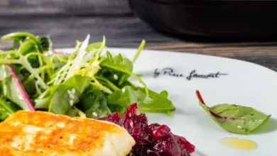 Grilovaný sýr Halloumi podávaný se salát a červeným ovocným omakem.