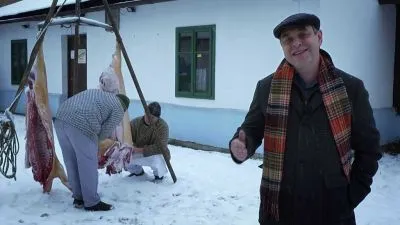 Muži zabíjejí prasat venku v sněhu pro masopust.