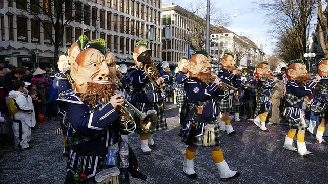 Masopust průvod s maskami a hudebníky na ulici.