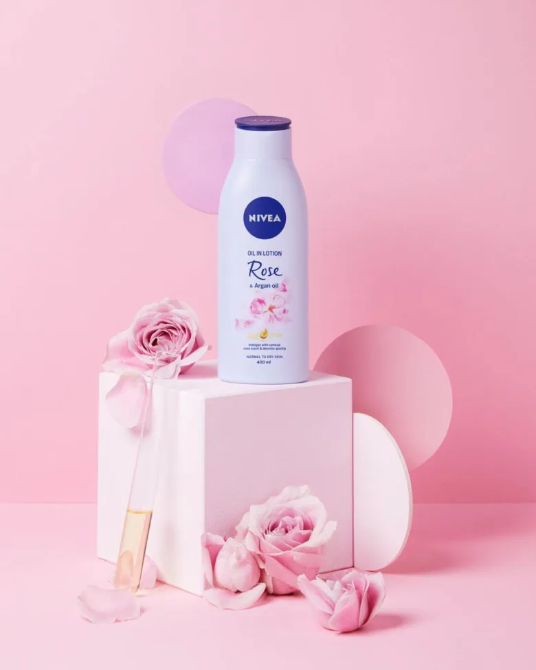 Fľaše s Arganovým olejem od značky Nivea mezi růžemi.