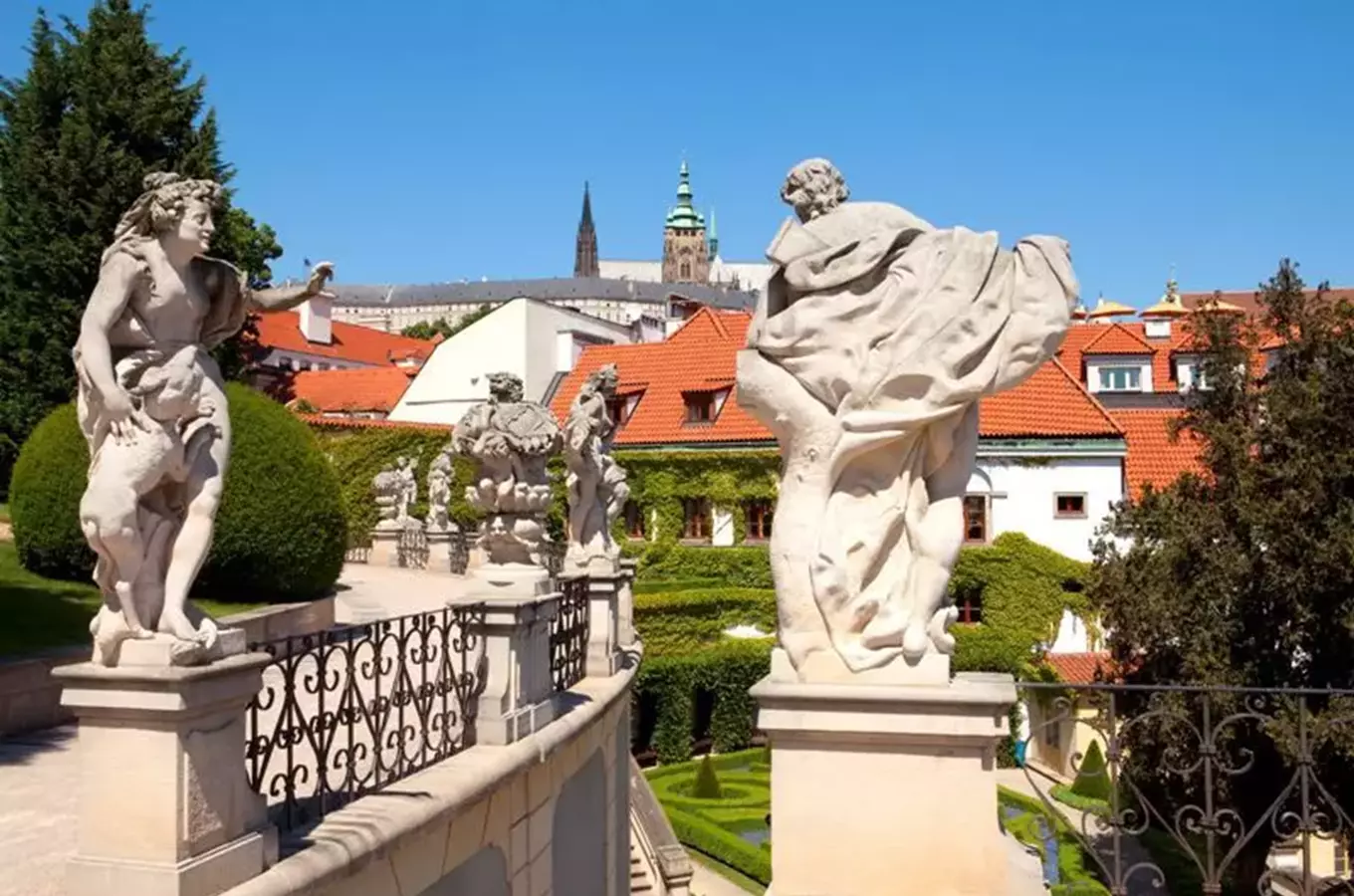 Sochy na terase s Pražským hradem v pozadí.